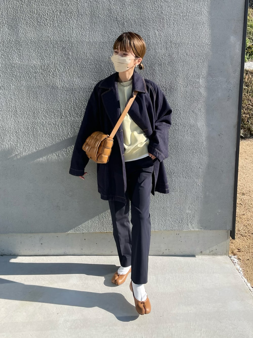 イエロー系のスウェット、ブラウン系のバレエシューズ、ブラウン系のショルダーバッグを着用したレディースの冬コーディネートの2枚目の写真