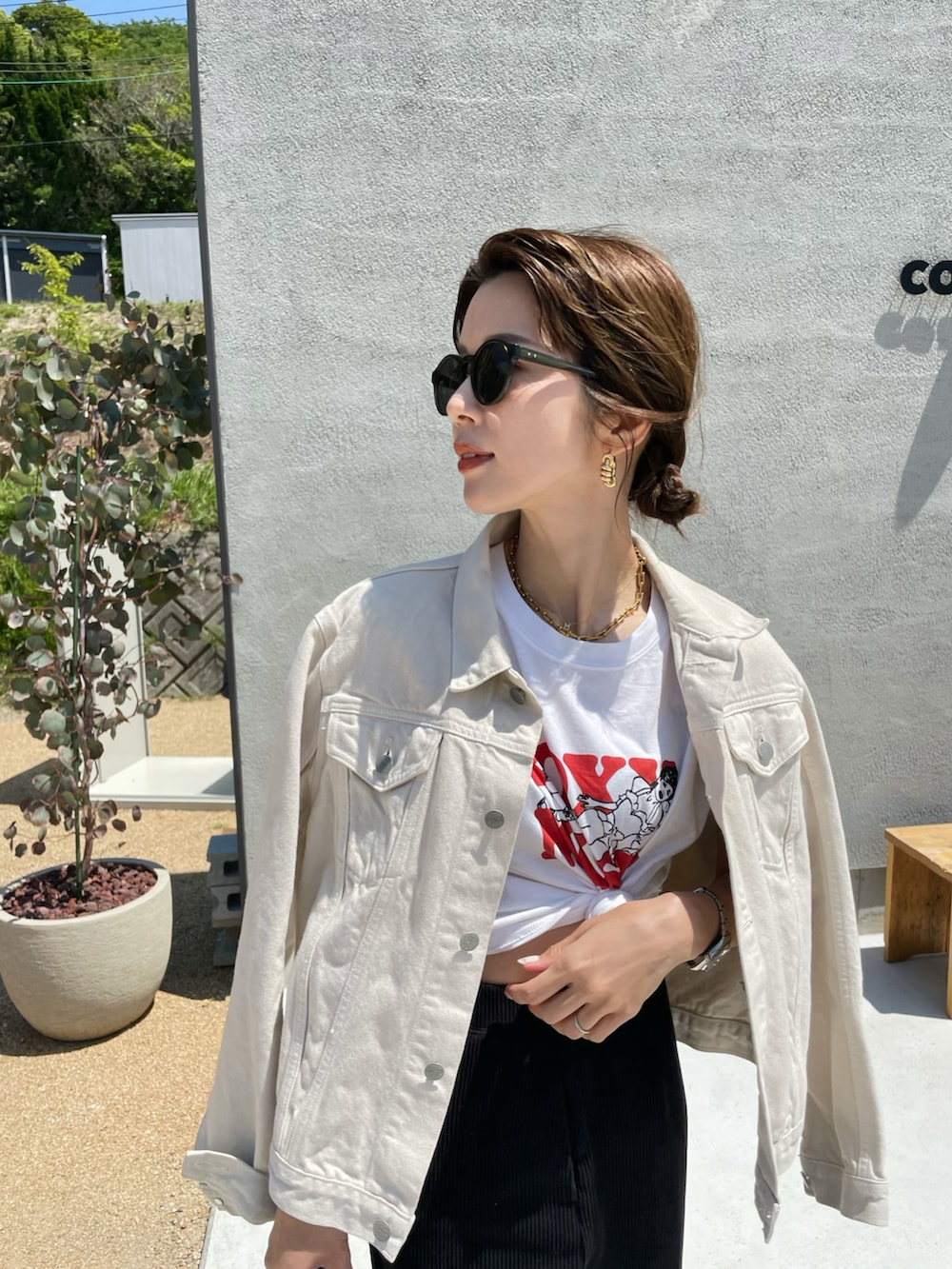 ホワイト系のデニムジャケット、ホワイト系のTシャツ/カットソー、ブラック系のスニーカーを着用したレディースの春コーディネートの2枚目の写真