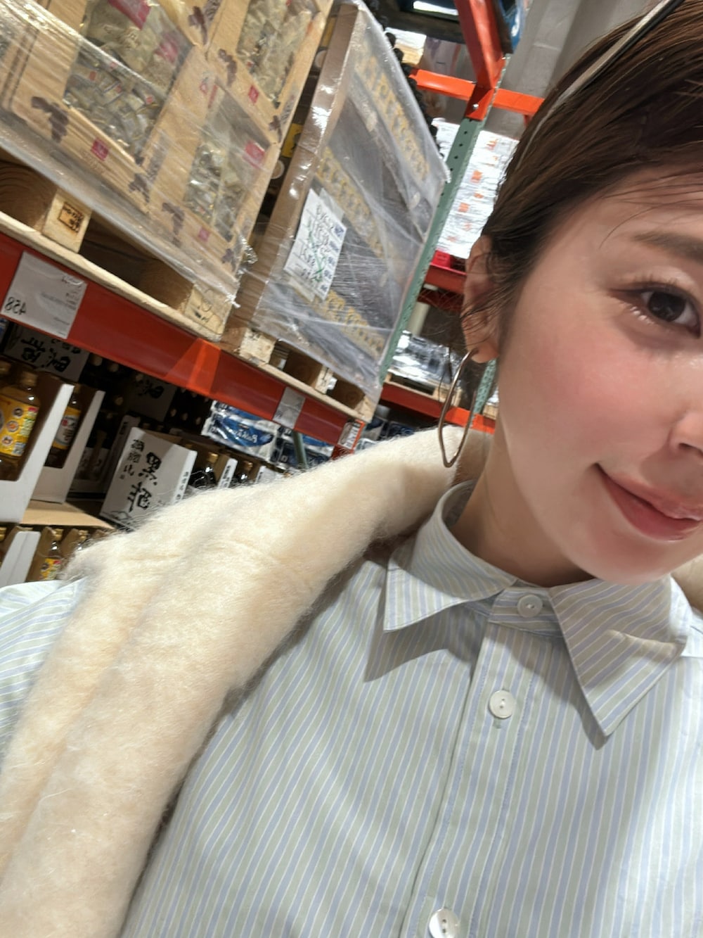 ホワイト系のニット/セーター、グリーン系のシャツ/ブラウス、ブルー系のスニーカーを着用したレディースの秋コーディネートの2枚目の写真