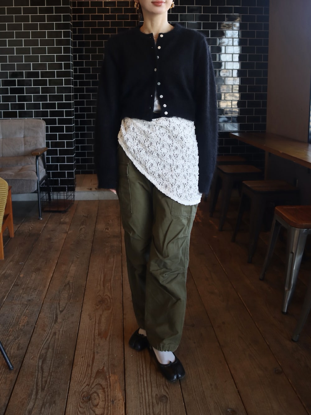 ブラック系のバレエシューズ、ブラック系のカーディガン/ボレロ、グリーン系のカーゴパンツを着用したレディースの冬コーディネートの2枚目の写真