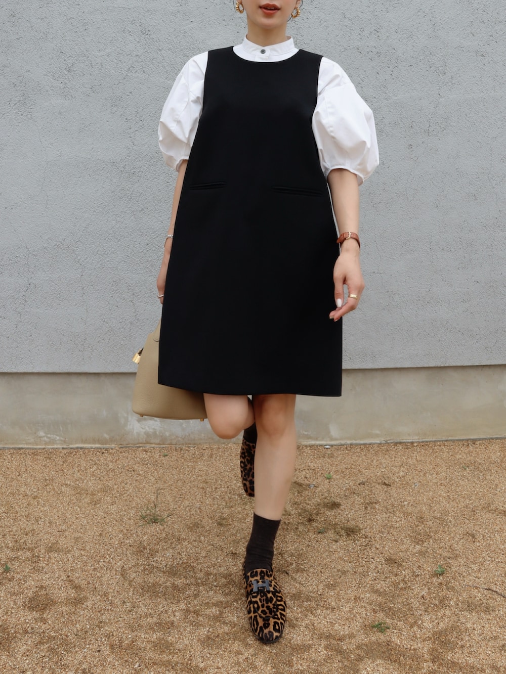 ブラック系のワンピース、ブラウン系のローファー、ホワイト系のシャツ/ブラウスを着用したレディースの夏コーディネートの2枚目の写真