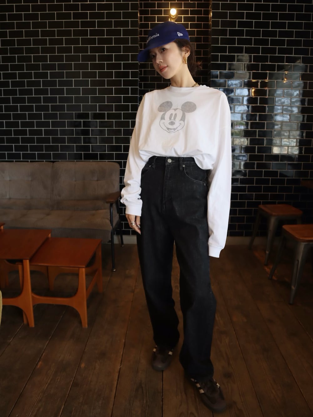 ブラウン系のスニーカー、ホワイト系のTシャツ/カットソー、ブラック系のデニムパンツを着用したレディースの冬コーディネートの2枚目の写真