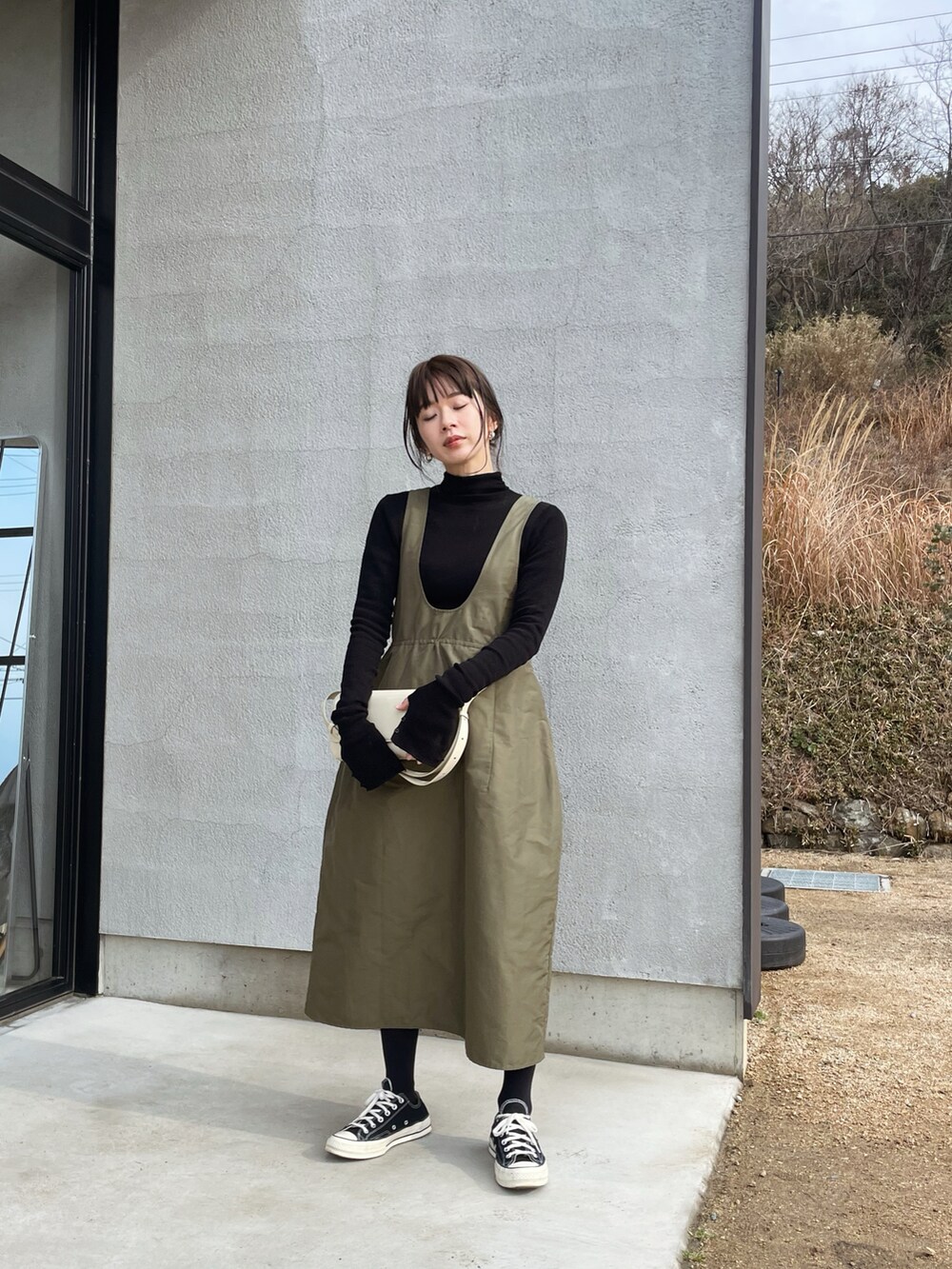 ブラック系のその他アウター、グリーン系のスカート、ブラック系のスニーカーを着用したレディースの冬コーディネートの2枚目の写真