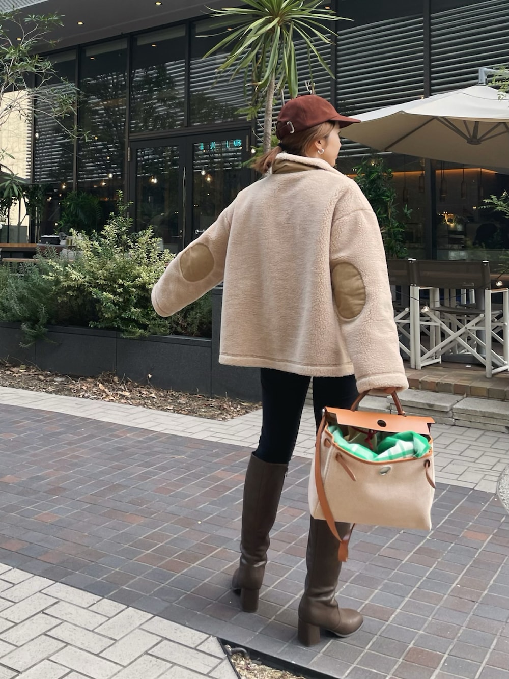 ベージュ系のその他トップス、ベージュ系のブーツ、ベージュ系のハンドバッグを着用したレディースの冬コーディネートの2枚目の写真