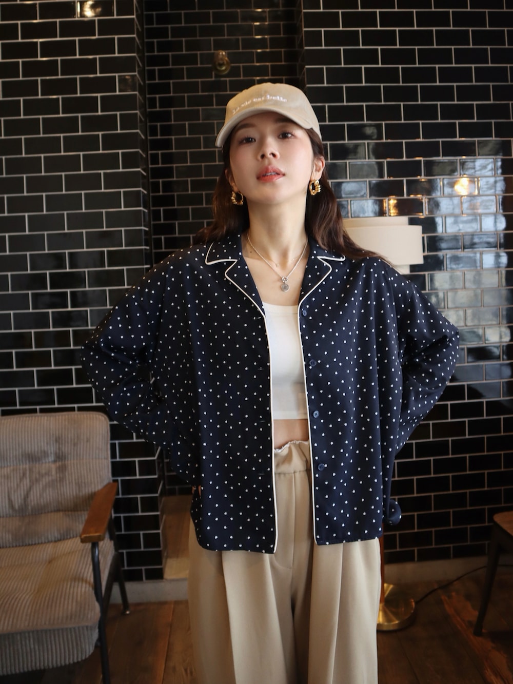 ホワイト系のタンクトップ、ブルー系のシャツ/ブラウス、ベージュ系のスラックスを着用したレディースの春コーディネートの2枚目の写真