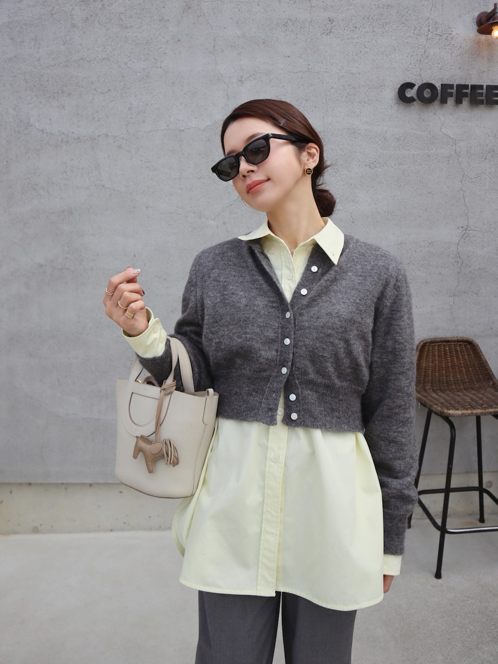 ブラック系のスニーカー、イエロー系のシャツ/ブラウス、グレー系のカーディガン/ボレロを着用したレディースの冬コーディネートの2枚目の写真