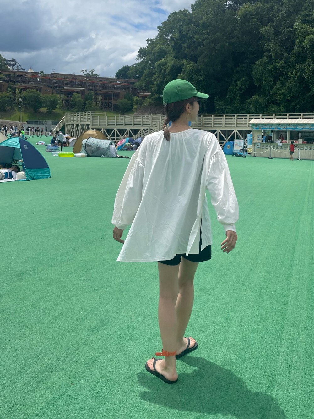 ホワイト系のラッシュガード、ブラック系の水着、グリーン系のサングラスを着用したレディースの夏コーディネートの2枚目の写真