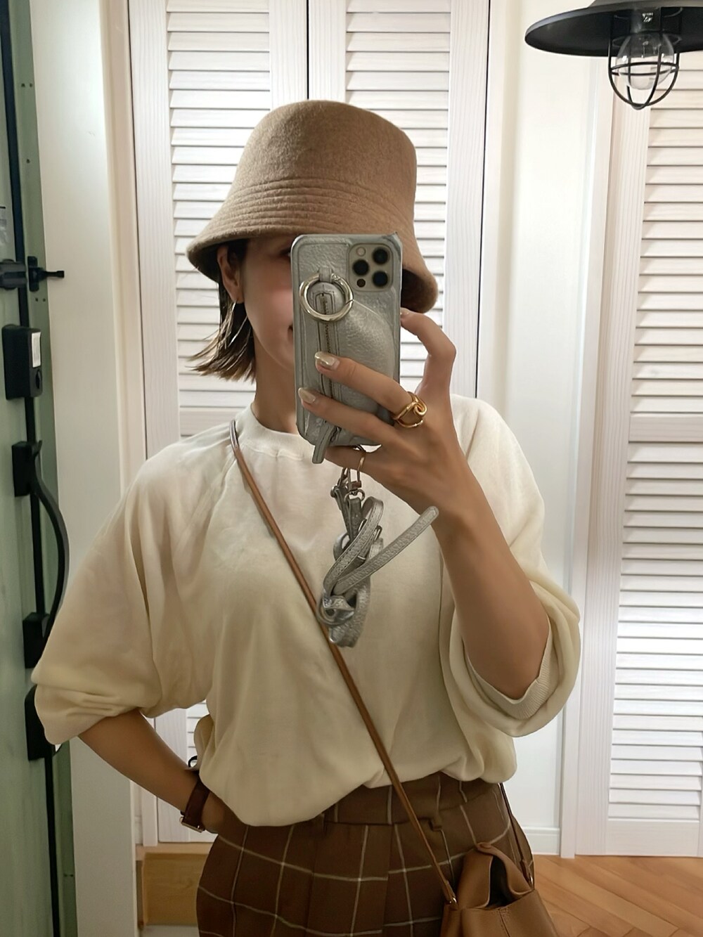 ホワイト系のニット/セーター、ブラウン系のパンツ、ブラウン系のハットを着用したレディースの夏コーディネートの2枚目の写真