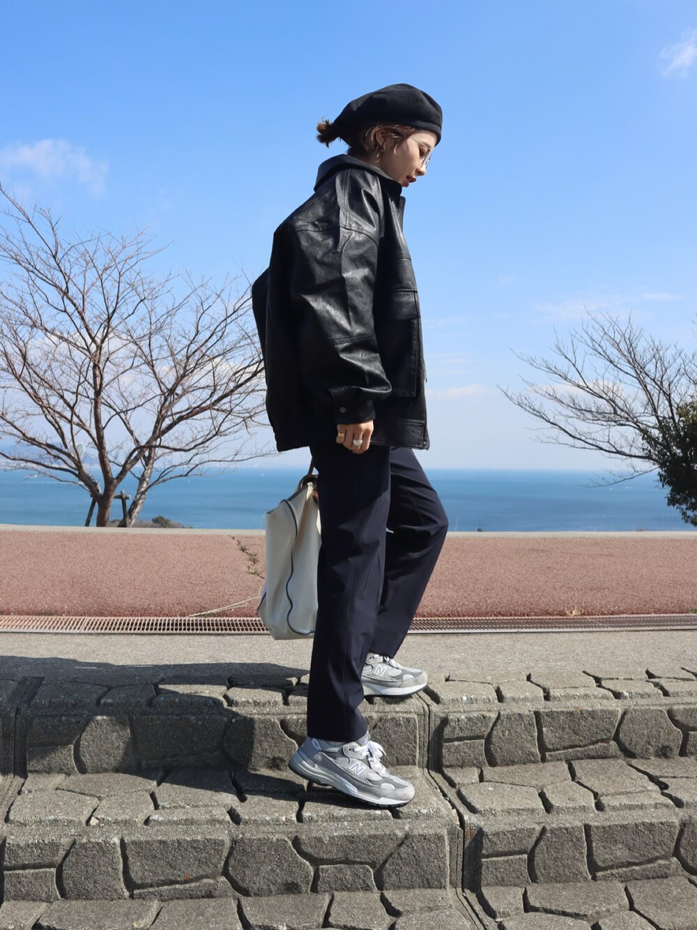 ブラック系のブルゾン、ホワイト系のTシャツ/カットソー、ブルー系のスウェットを着用したレディースの冬コーディネートの3枚目の写真