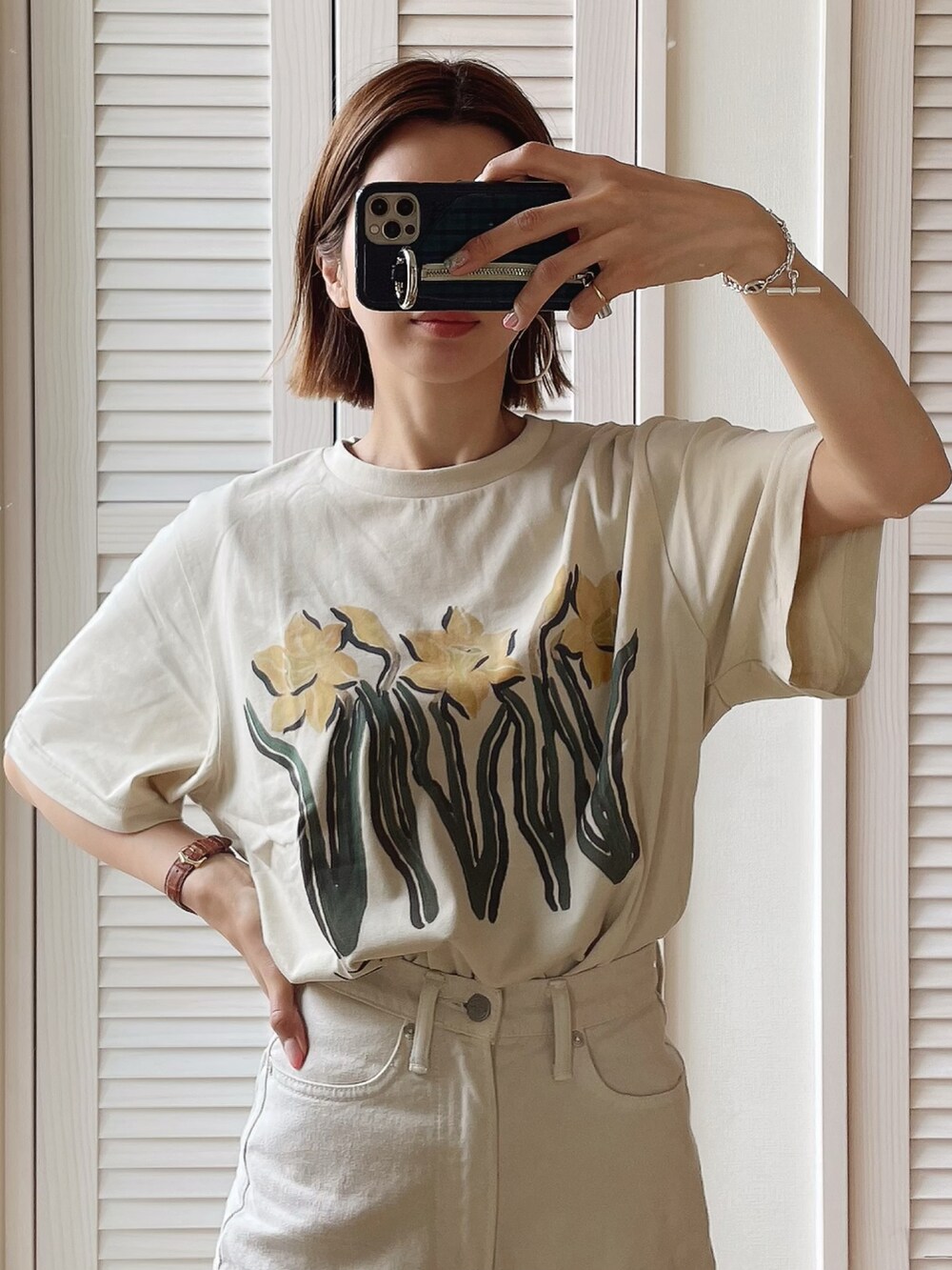 ホワイト系のデニムパンツ、ベージュ系のトレンチコート、ベージュ系のTシャツ/カットソーを着用したレディースの春コーディネートの2枚目の写真