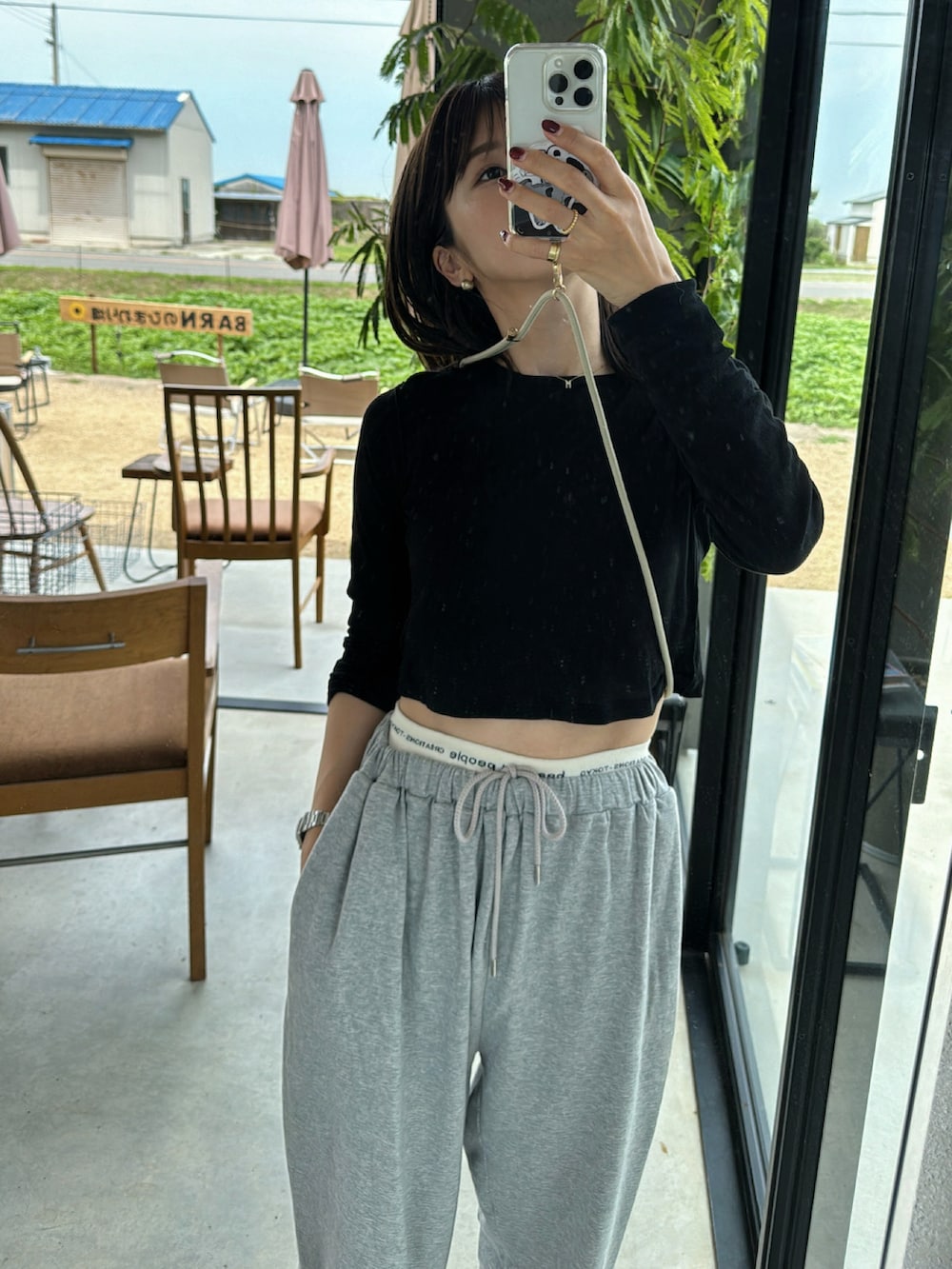 ブラック系のTシャツ/カットソー、グレー系のスウェットパンツ、ブラック系のサンダルを着用したレディースの夏コーディネートの3枚目の写真