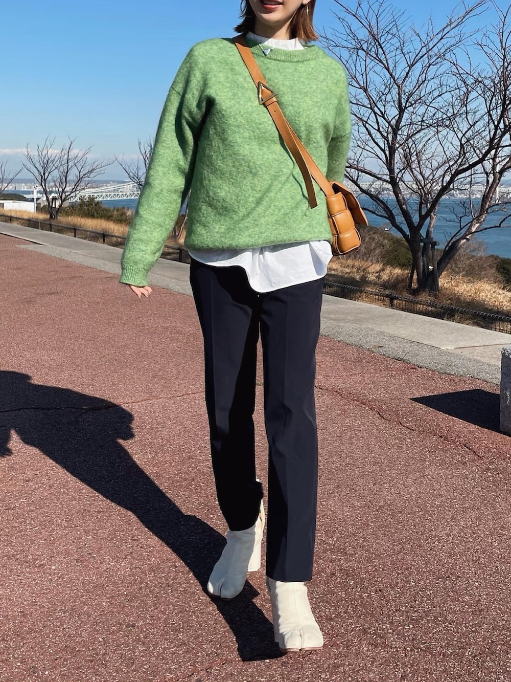 ブルー系のデニムジャケット、グリーン系のニット/セーター、ブルー系のその他パンツを着用したレディースの冬コーディネートの2枚目の写真