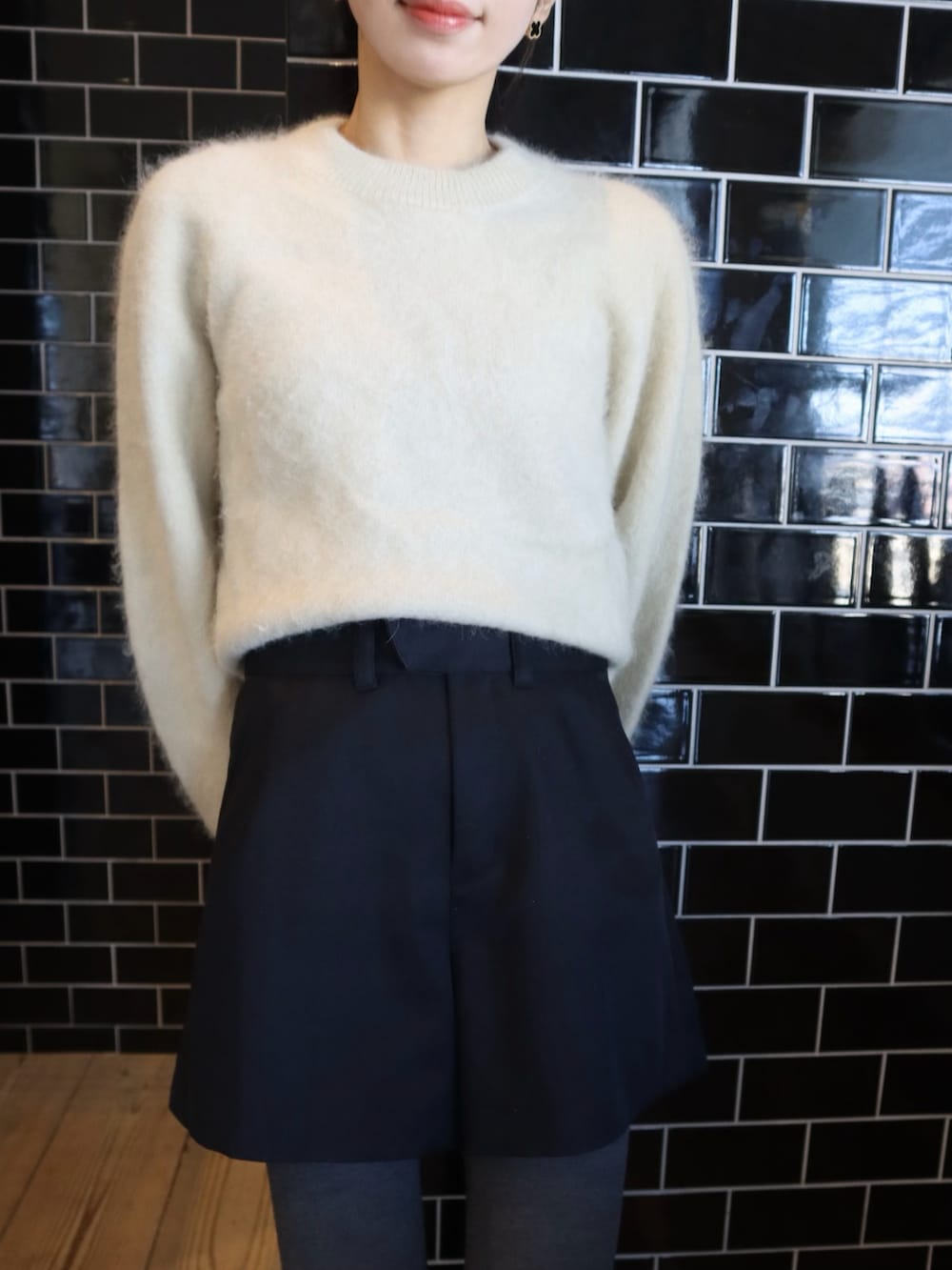 ベージュ系のニット/セーター、ブラック系のその他パンツ、ベージュ系のスニーカーを着用したレディースの冬コーディネートの2枚目の写真