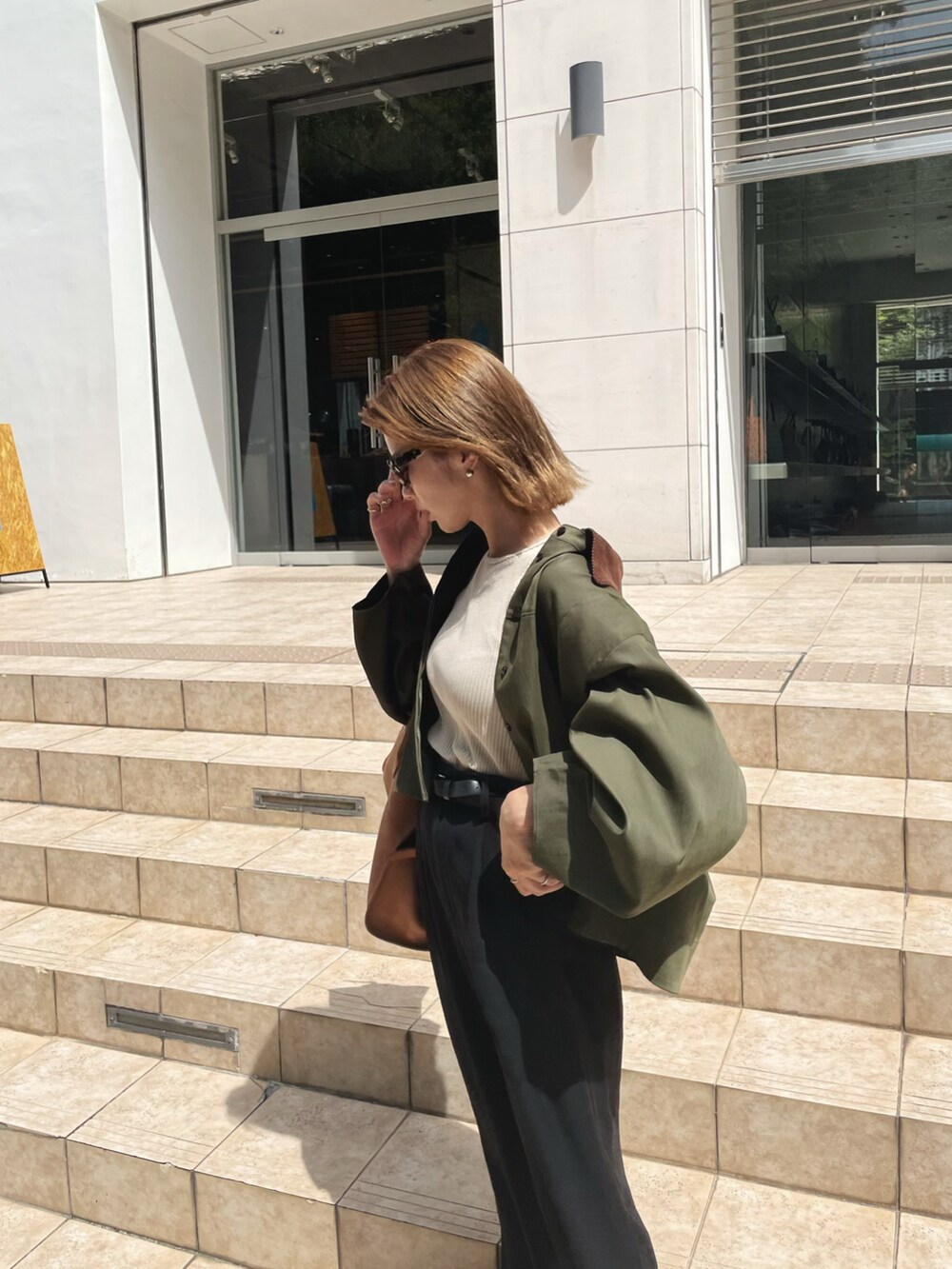 ベージュ系のタンクトップ、グリーン系のシャツ/ブラウス、ブラック系のスラックスを着用したレディースの夏コーディネートの3枚目の写真