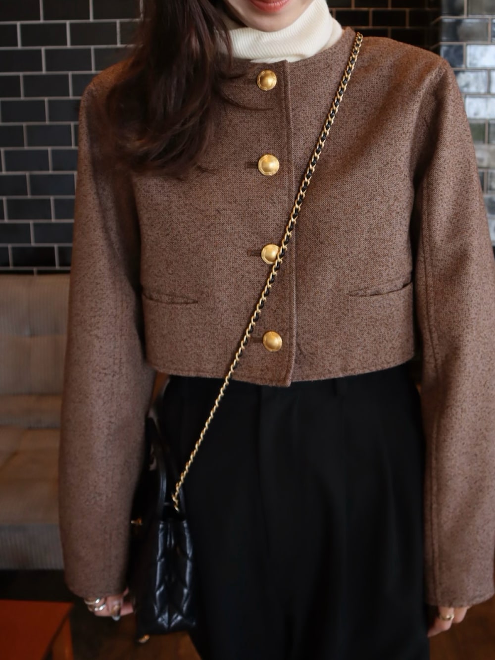 ブラウン系のノーカラージャケット、ブラック系のローファーを着用したレディースの冬コーディネートの2枚目の写真