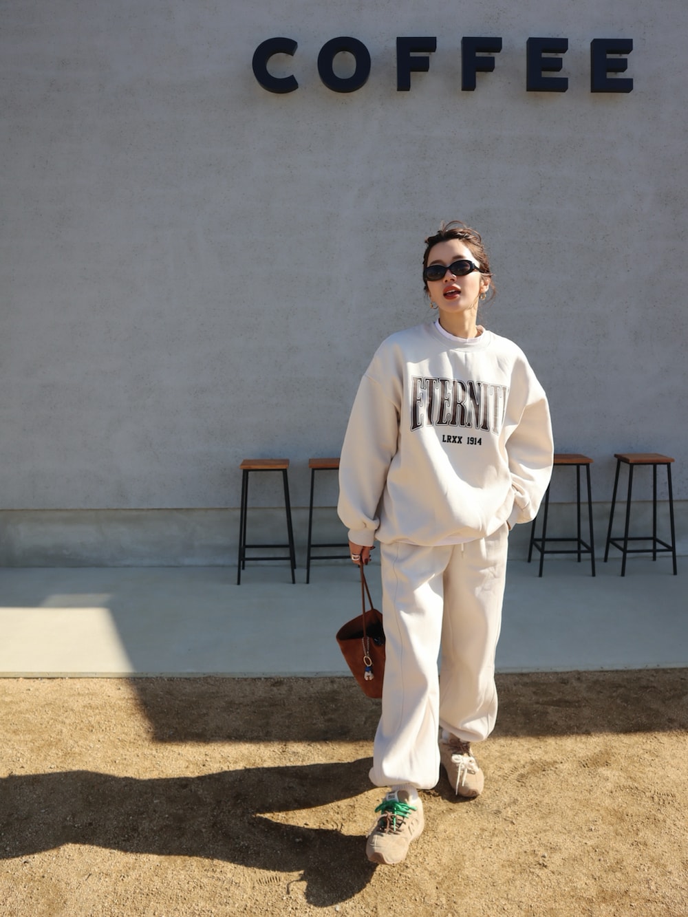 ブラウン系のスウェット、ブラウン系のスウェットパンツ、グリーン系のTシャツ/カットソーを着用したレディースの冬コーディネートの2枚目の写真