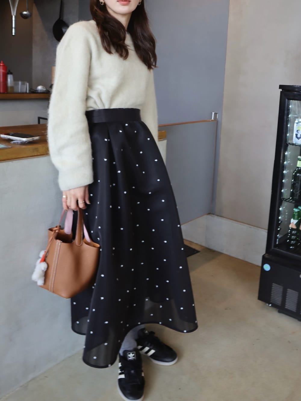 ブラウン系のMA-1、ブラック系のスカート、ブラック系のスニーカーを着用したレディースの冬コーディネートの2枚目の写真