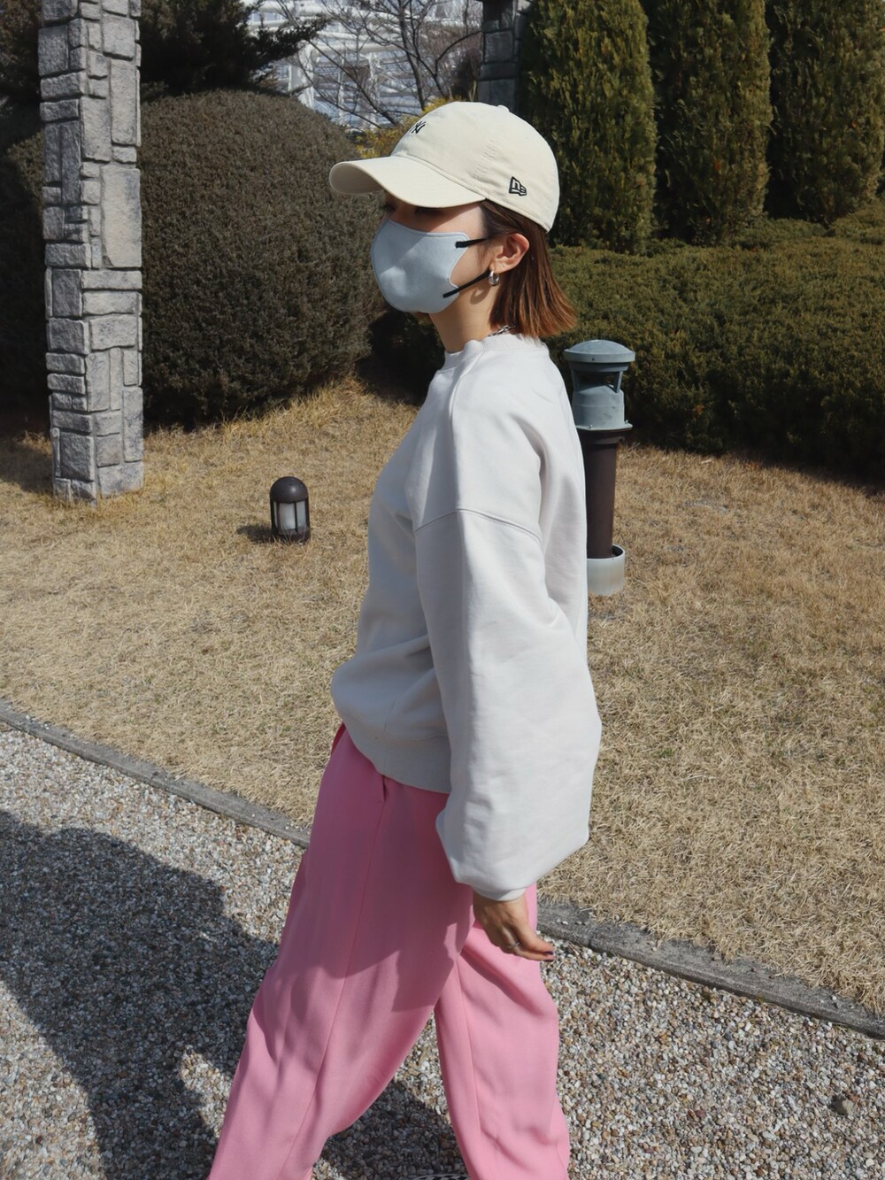 ホワイト系のスウェット、ピンク系のスラックス、その他のスニーカーを着用したレディースの春コーディネートの2枚目の写真