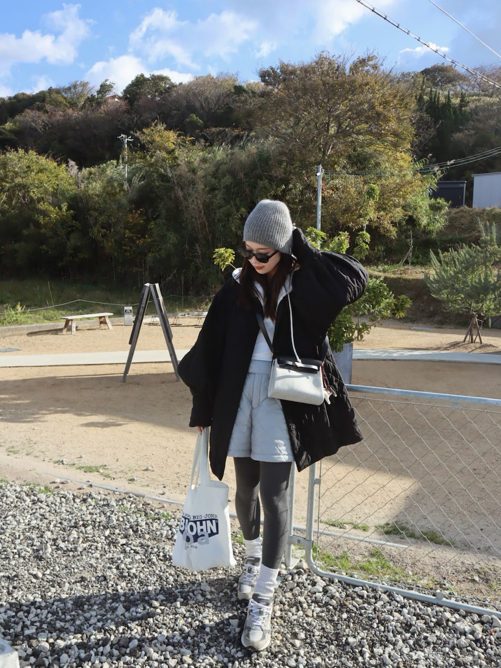 グレー系のパンツ、グレー系のタイツ/ストッキング、グレー系のニットキャップ/ビーニーを着用したレディースの冬コーディネートの2枚目の写真