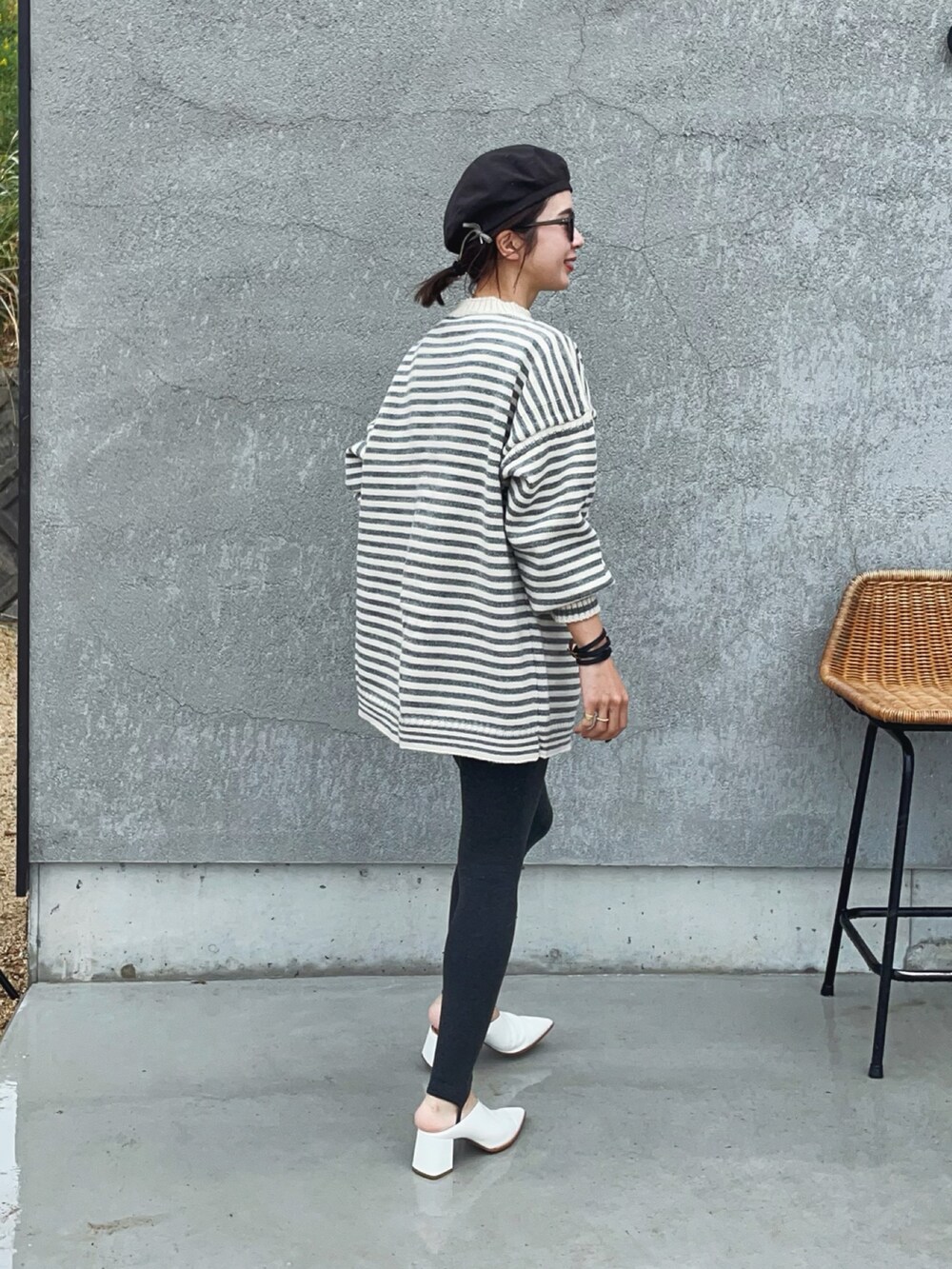 グレー系のニット/セーター、ブラック系のハンチング/ベレー帽、グレー系のレギンス/スパッツを着用したレディースの秋コーディネートの2枚目の写真