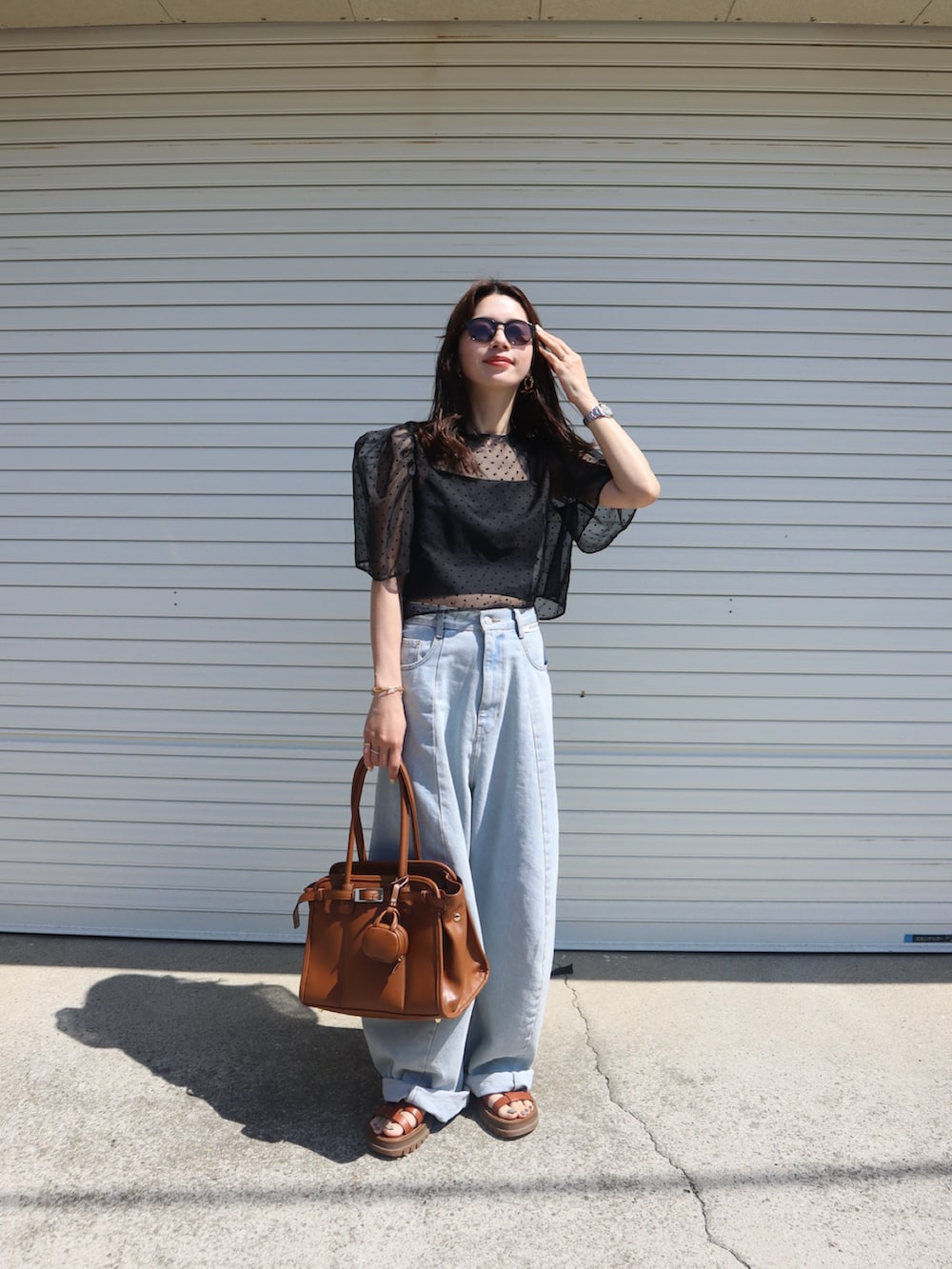 ブルー系のデニムパンツ、ブラック系のシャツ/ブラウス、ブラック系のキャミソールを着用したレディースの春コーディネートの2枚目の写真