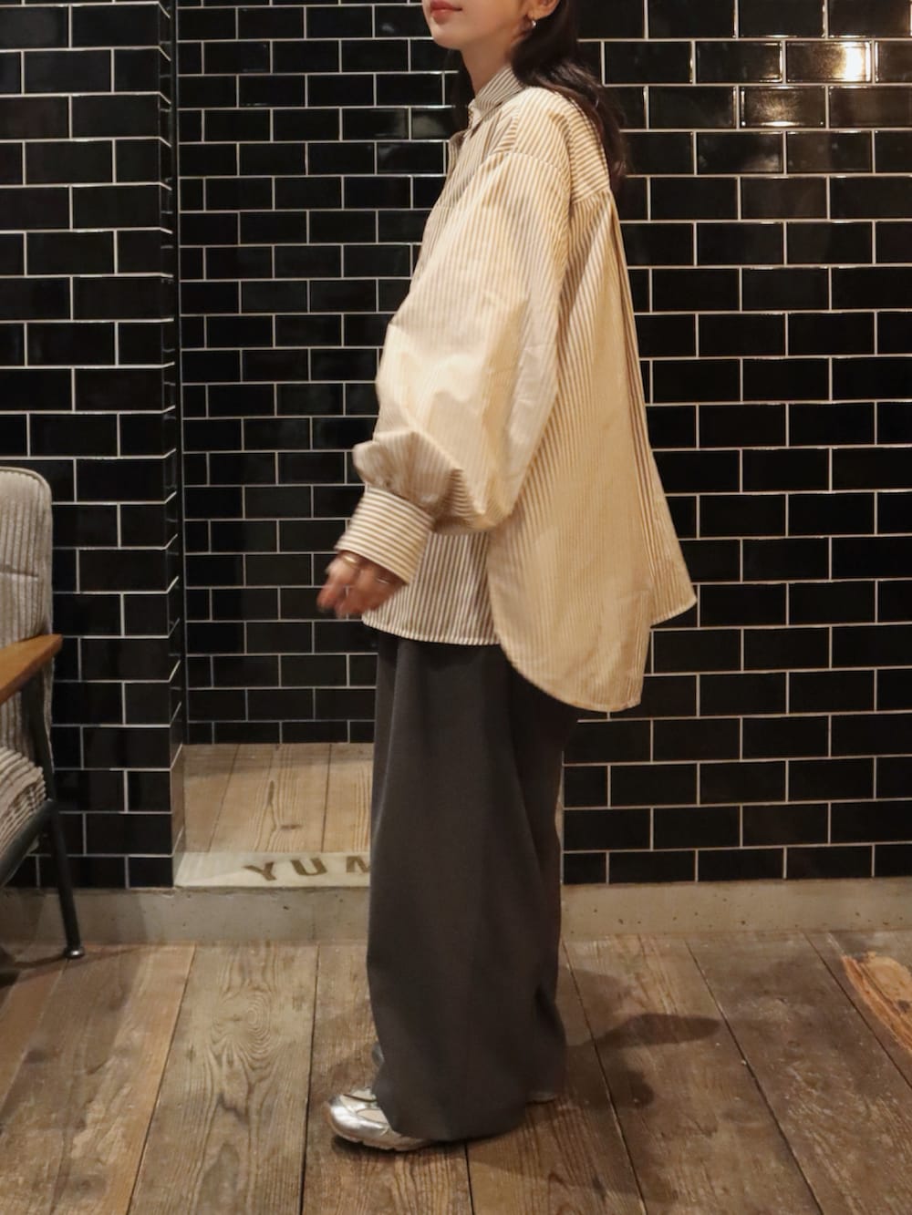 ブラウン系のシャツ/ブラウス、グレー系のスラックス、シルバー系のスニーカーを着用したレディースの冬コーディネートの2枚目の写真