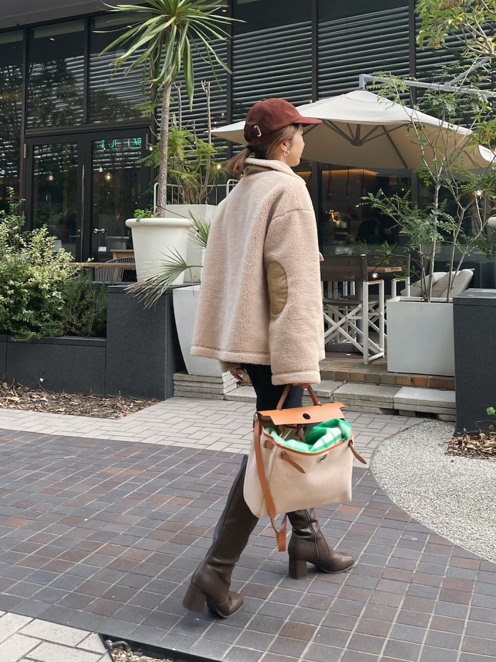 ベージュ系のその他トップス、ベージュ系のブーツ、ベージュ系のハンドバッグを着用したレディースの冬コーディネートの3枚目の写真