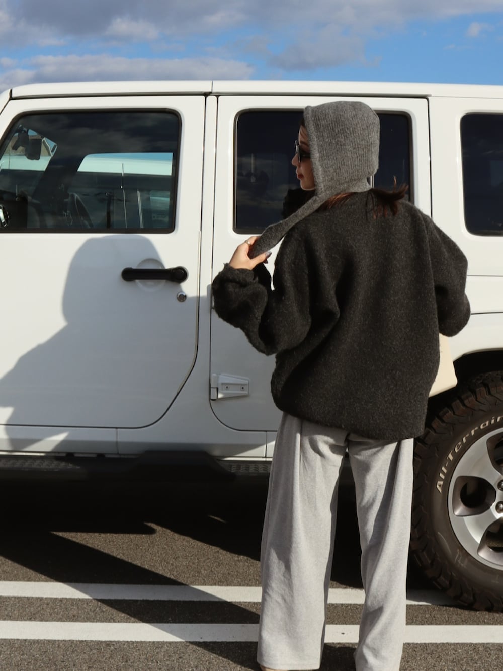 グレー系のニット/セーター、グレー系のスウェットパンツ、ベージュ系のスニーカーを着用したレディースの秋コーディネートの3枚目の写真