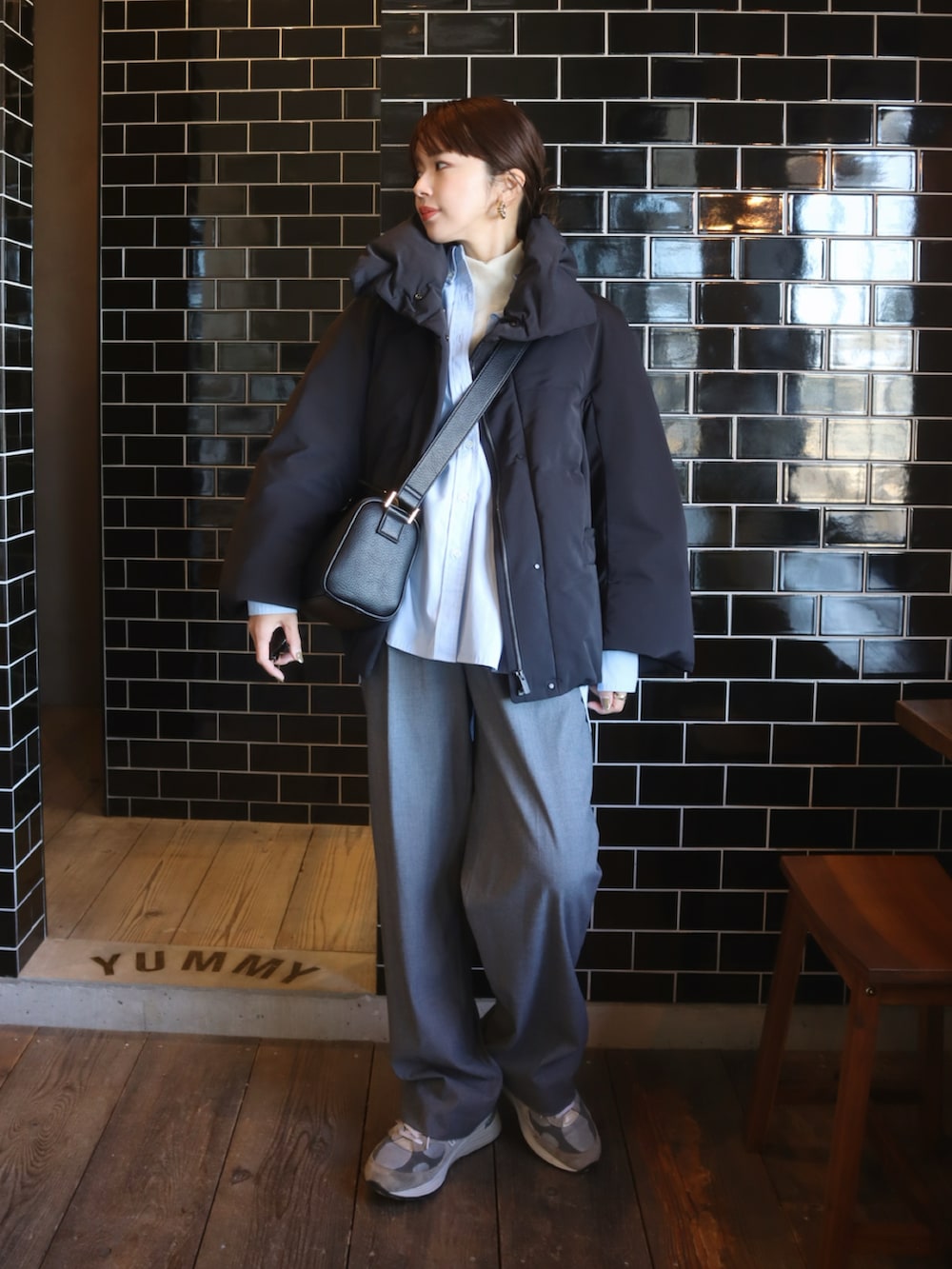 ブルー系のシャツ/ブラウス、グレー系のスラックス、ブラック系のダウンジャケット/コートを着用したレディースの冬コーディネートの2枚目の写真