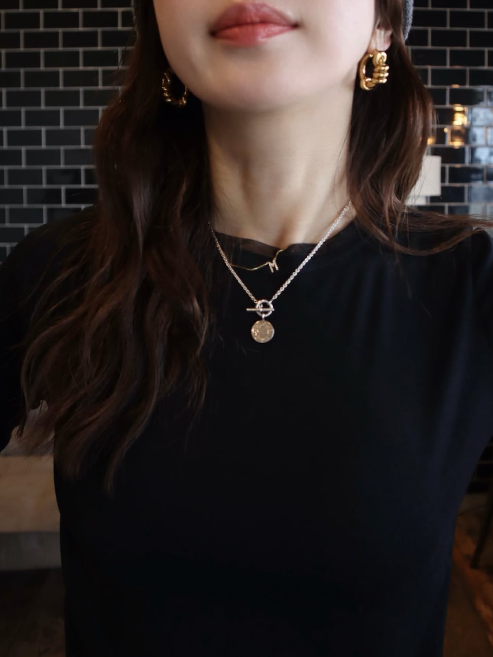 ブラック系のTシャツ/カットソー、ブルー系のデニムパンツ、ベージュ系のハンドバッグを着用したレディースの春コーディネートの2枚目の写真