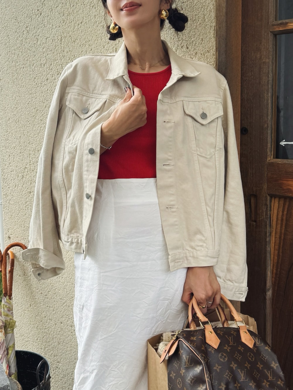 ホワイト系のデニムジャケット、ホワイト系のスカート、ホワイト系のスニーカーを着用したレディースの秋コーディネートの2枚目の写真