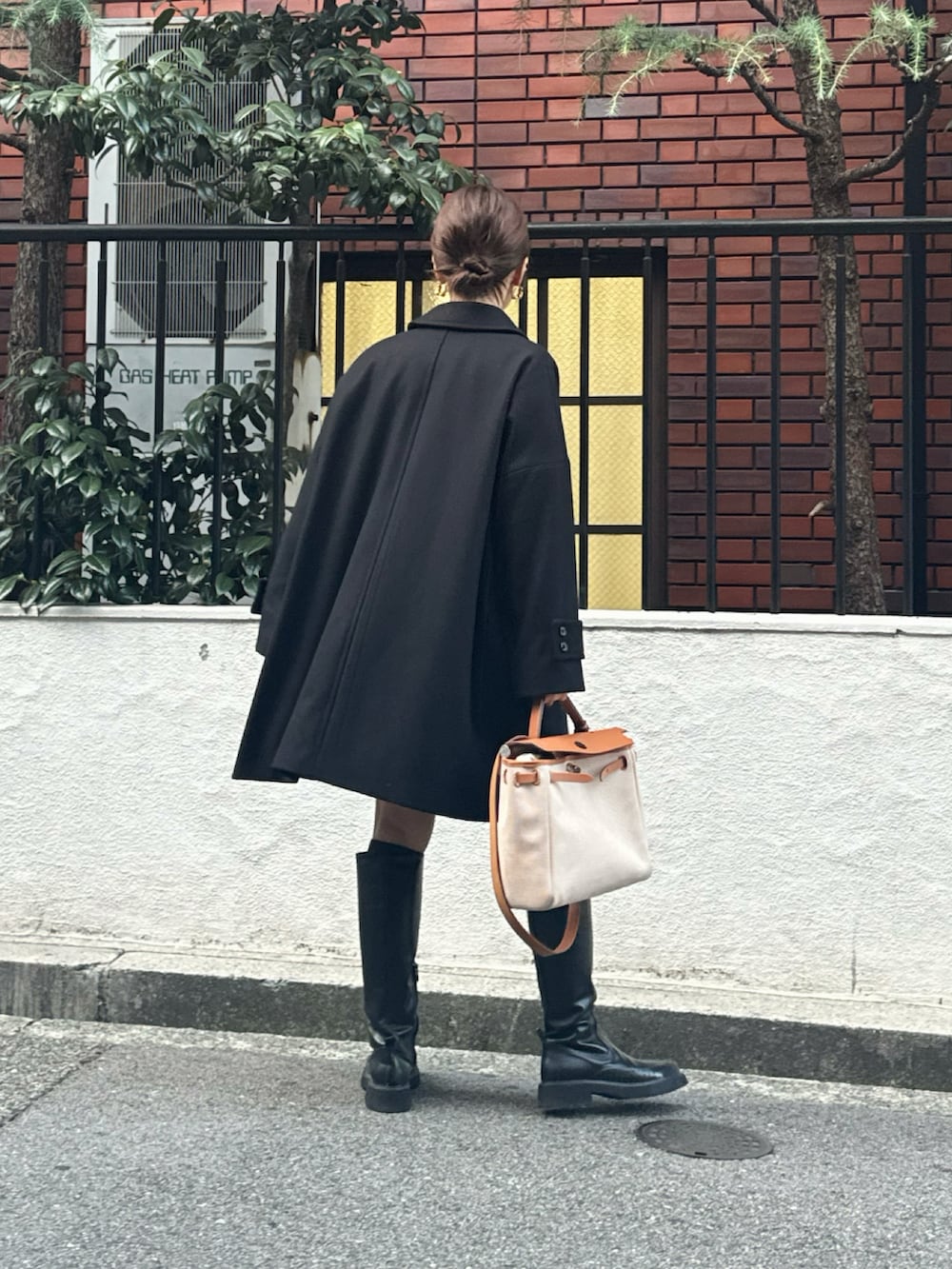 グレー系のカーディガン/ボレロ、ブラック系のステンカラーコートを着用したレディースの秋コーディネートの2枚目の写真