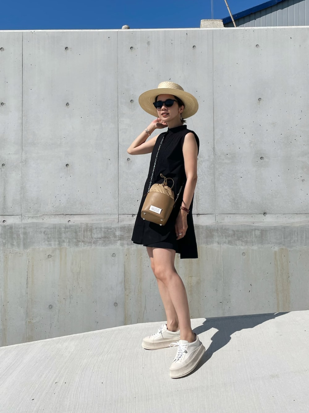 ブラック系のシャツ/ブラウス、ホワイト系のスニーカー、ベージュ系のハットを着用したレディースの夏コーディネートの2枚目の写真