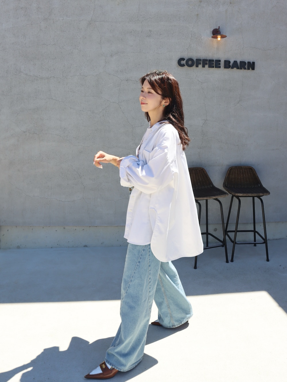 ブルー系のデニムパンツ、ホワイト系のTシャツ/カットソー、ホワイト系のシャツ/ブラウスを着用したレディースの秋コーディネートの2枚目の写真