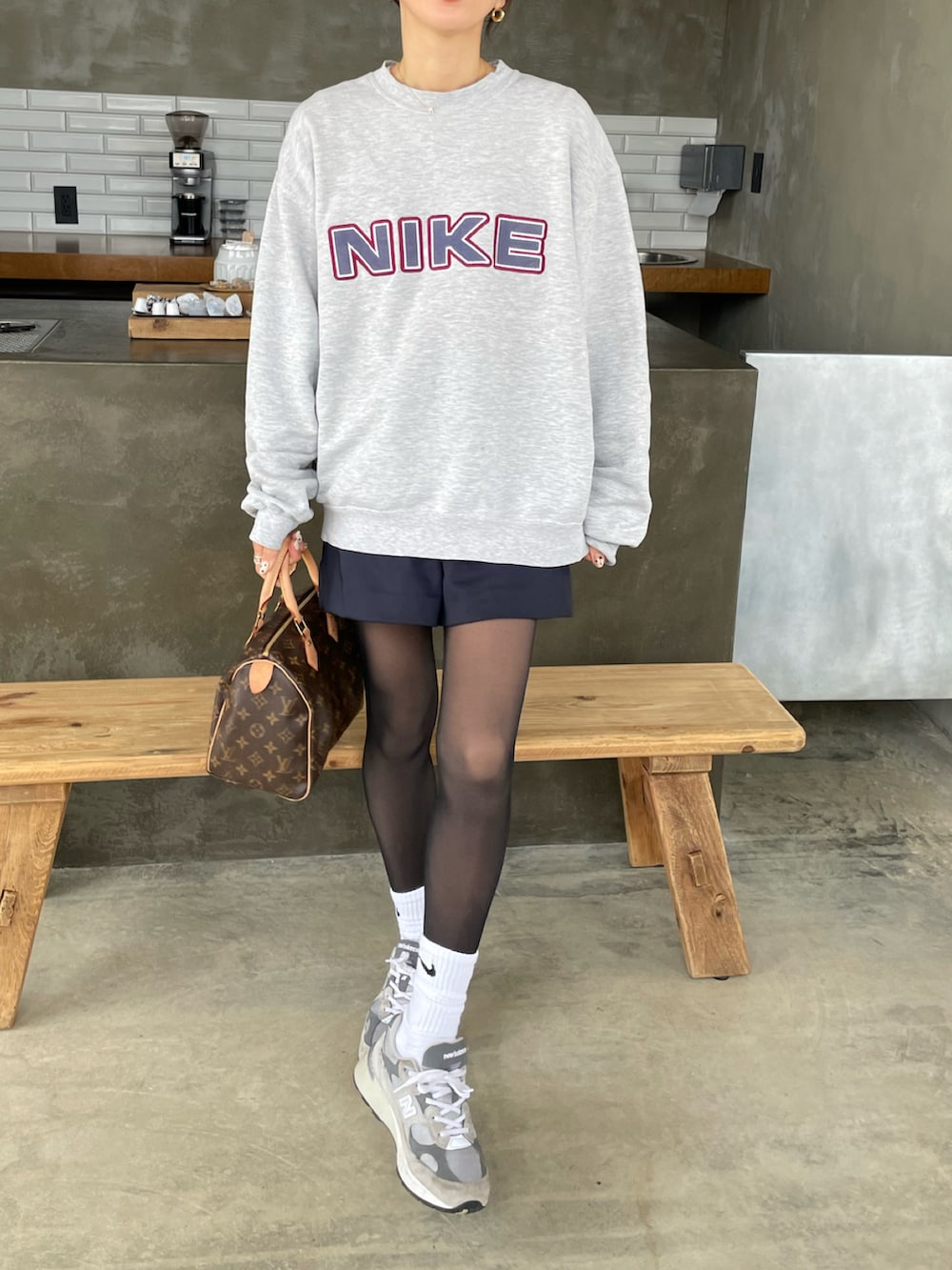 ブルー系のパンツ、グレー系のスニーカー、ブラウン系のハンドバッグを着用したレディースの冬コーディネートの2枚目の写真