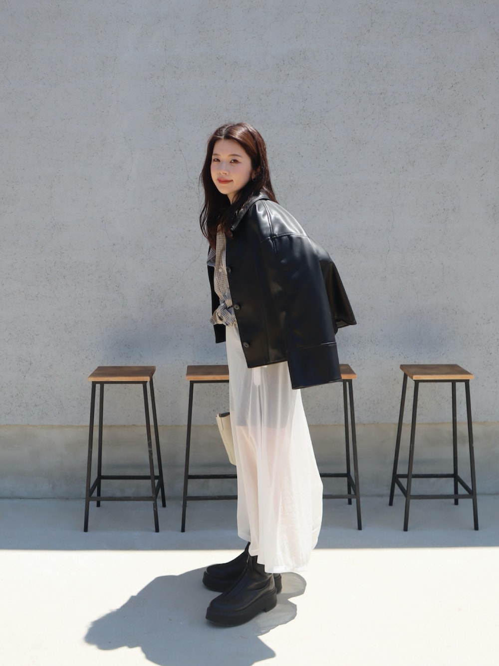 ホワイト系のスカート、ホワイト系のタンクトップ、ブラック系のその他アウターを着用したレディースの夏コーディネートの2枚目の写真