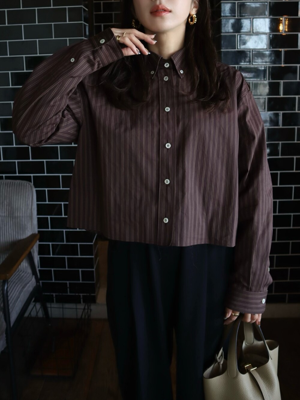 ブラウン系のシャツ/ブラウス、ブラック系のその他パンツ、ベージュ系のハンドバッグを着用したレディースの秋コーディネートの3枚目の写真