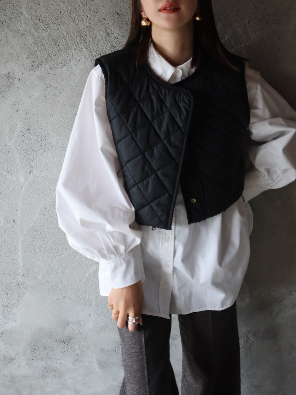 ブラック系のその他アウター、ホワイト系のシャツ/ブラウス、ブラック系のローファーを着用したレディースの冬コーディネートの2枚目の写真