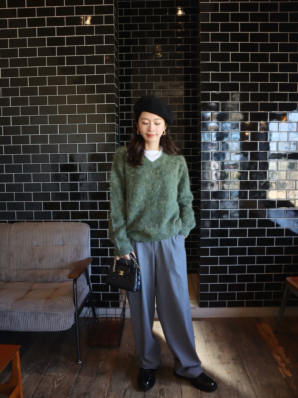 グリーン系のニット/セーター、ブラック系のハンチング/ベレー帽を着用したレディースの秋コーディネートの2枚目の写真