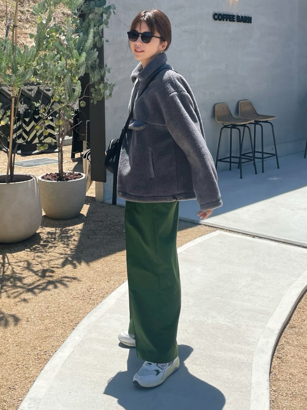 グレー系のジャケット/アウター、グリーン系のスラックス、ホワイト系のスニーカーを着用したレディースの秋コーディネートの2枚目の写真
