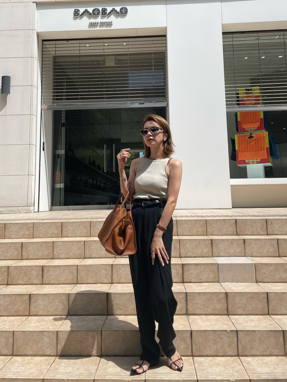 ベージュ系のタンクトップ、グリーン系のシャツ/ブラウス、ブラック系のスラックスを着用したレディースの夏コーディネートの4枚目の写真