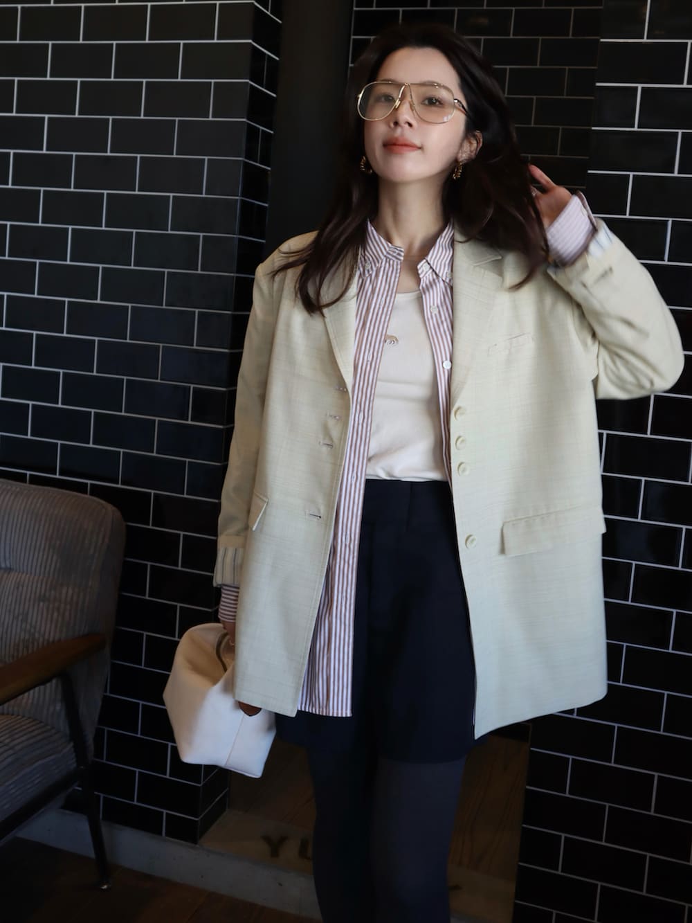 イエロー系のテーラードジャケット、ブラック系のローファー、グレー系のタイツ/ストッキングを着用したレディースの冬コーディネートの2枚目の写真