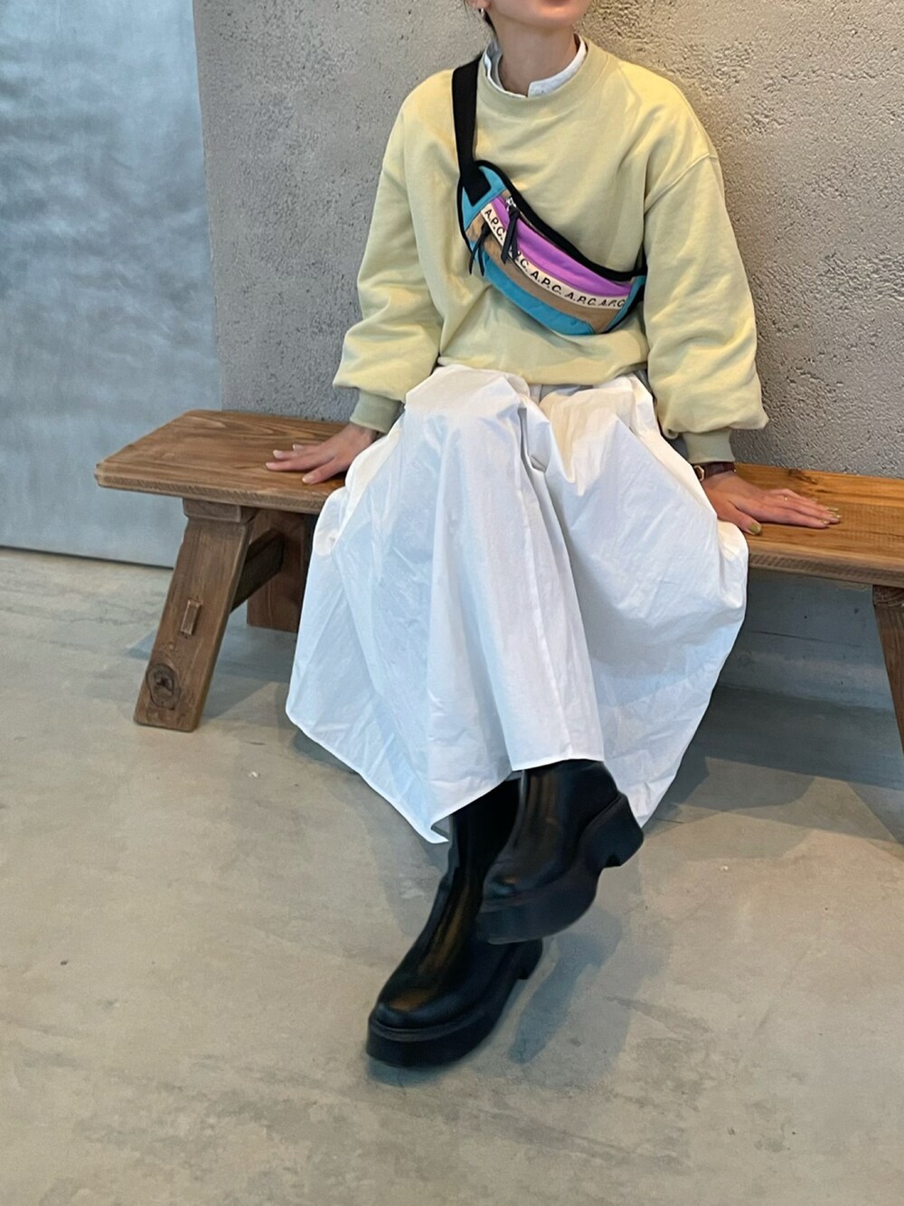 イエロー系のスウェット、その他のボディバッグ/ウエストポーチ、ホワイト系のシャツワンピースを着用したレディースの冬コーディネートの2枚目の写真