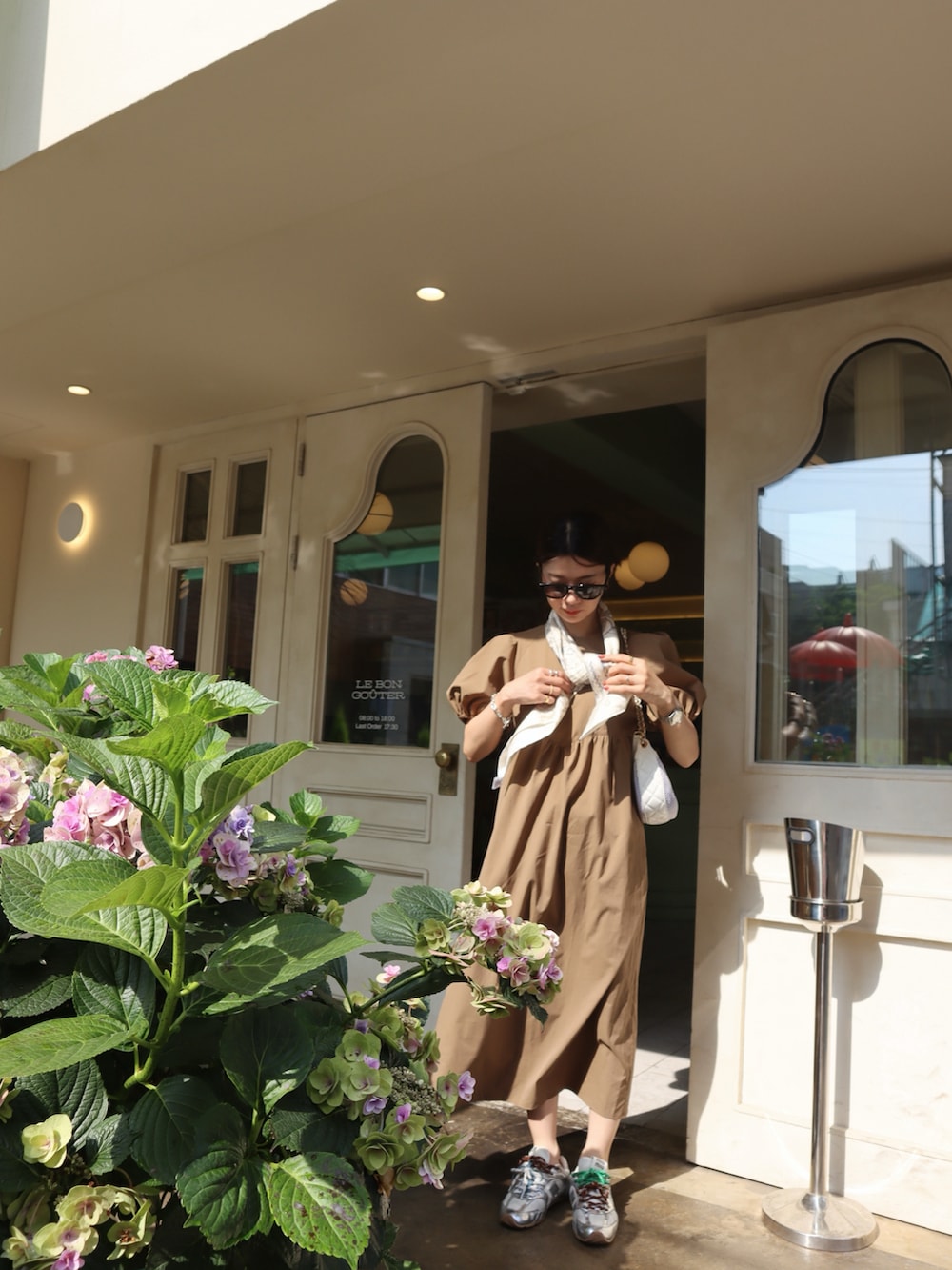 ブラウン系のワンピース、ホワイト系のストール/ショール、ベージュ系のコンシーラーを着用したレディースの夏コーディネートの2枚目の写真