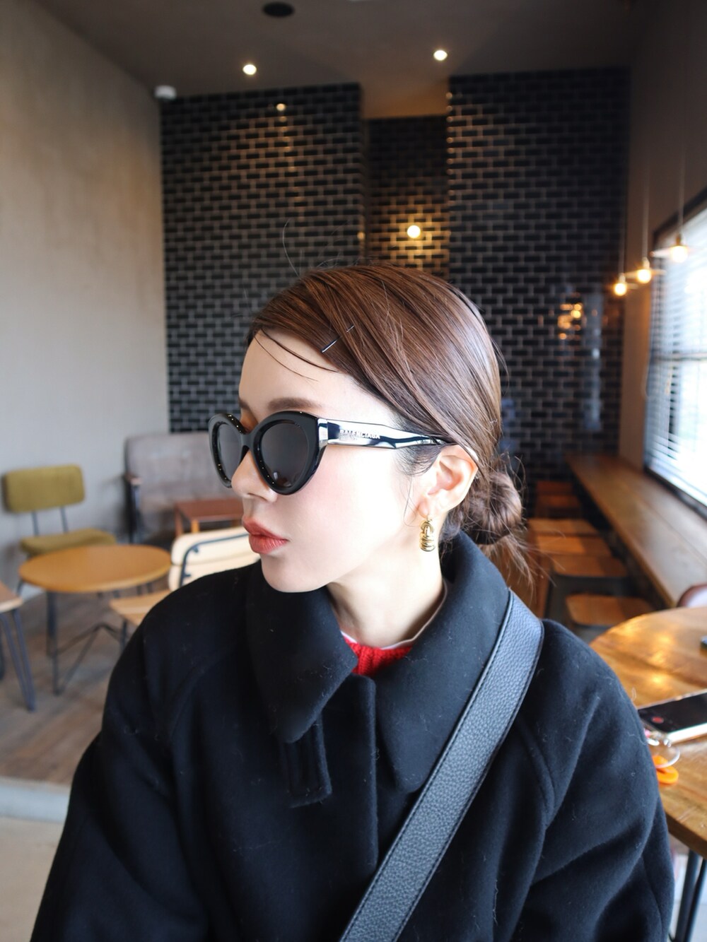 ブルー系のスニーカー、ベージュ系のチノパンツ、ブラック系のその他アウターを着用したレディースの冬コーディネートの2枚目の写真