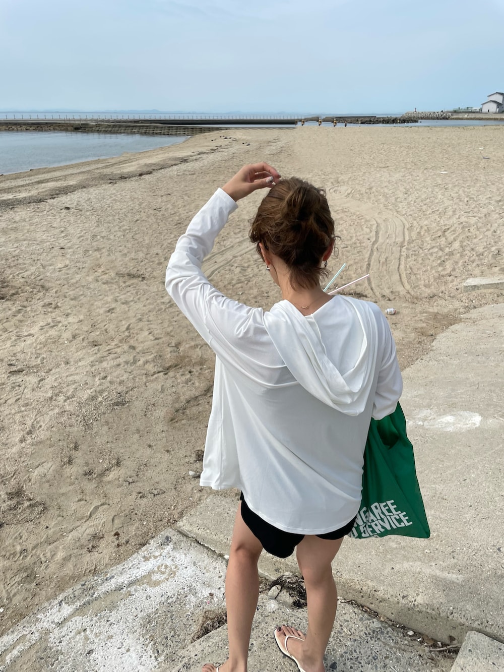 ブラック系の水着、ホワイト系のラッシュガードを着用したレディースの夏コーディネートの2枚目の写真