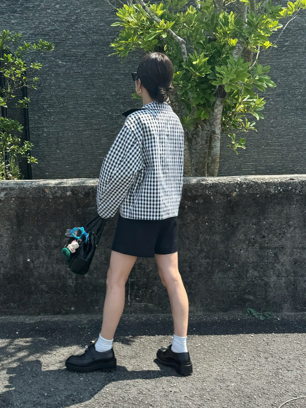 ブルー系のジャケット/アウター、ブラック系のその他パンツ、ブラック系のボストンバッグを着用したレディースの夏コーディネートの2枚目の写真