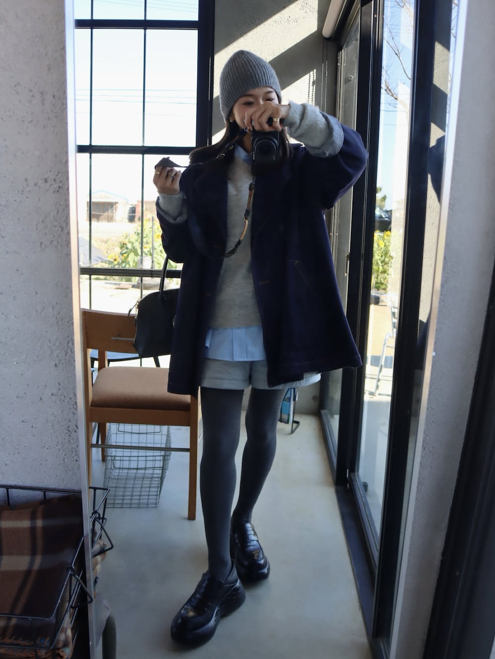 ブルー系のデニムジャケット、グレー系のニット/セーター、グレー系のパンツを着用したレディースの冬コーディネートの2枚目の写真