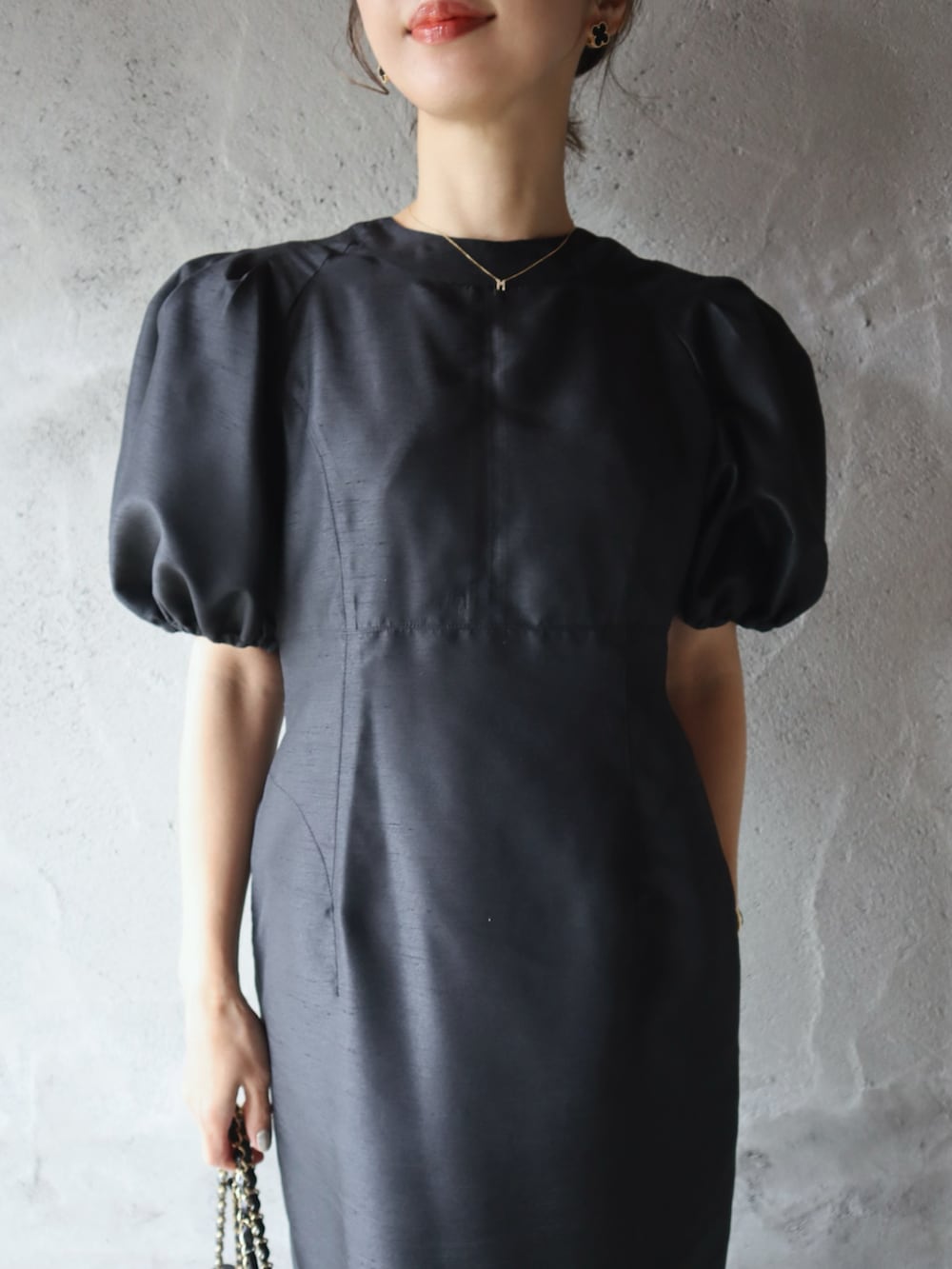 ブラック系のパンプス、ブラック系のドレス、ピンク系のアイシャドウを着用したレディースの春コーディネートの4枚目の写真