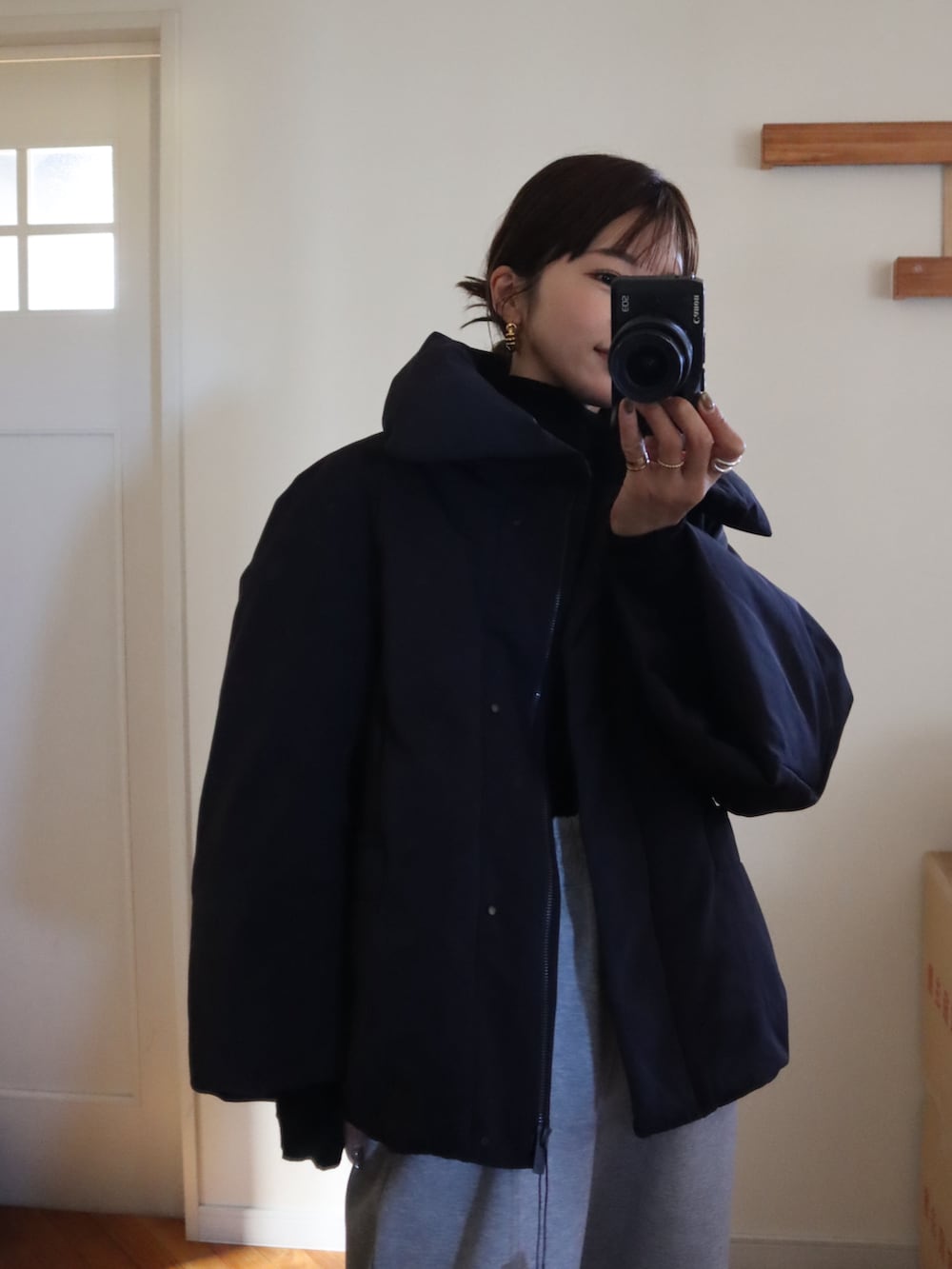 ブラック系のダウンジャケット/コート、グレー系のスウェットパンツ、イエロー系のシャツ/ブラウスを着用したレディースの冬コーディネートの3枚目の写真